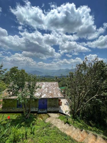 an old house on a hill with trees in front at Joy Source Resort in Kathmandu