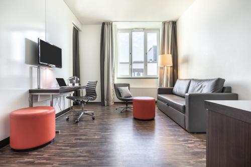 a living room with a couch and a desk at Garner Hotel Berlin - Mitte by IHG in Berlin