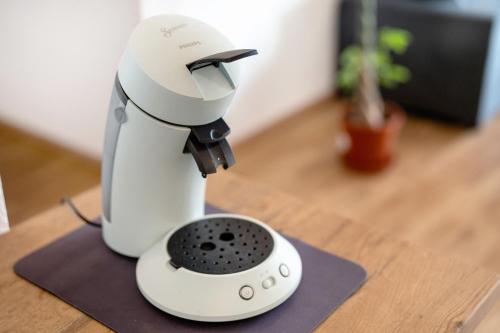 a white mixer sitting on top of a wooden table at White House Apartments in Kappel-Grafenhausen