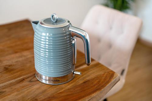 a tea kettle sitting on a wooden table at White House Apartments in Kappel-Grafenhausen