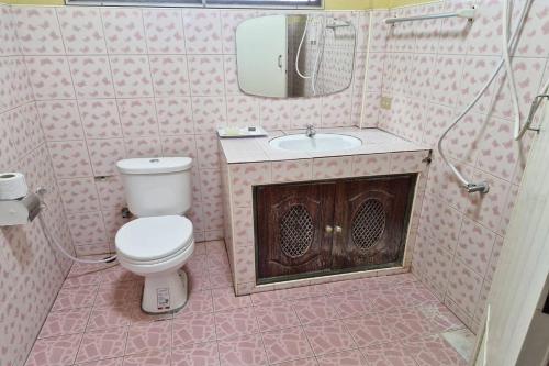 a bathroom with a toilet and a sink and a mirror at Tontarn Resort and Spa in Khanom