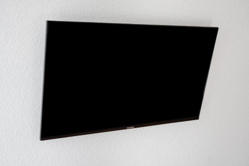a flat screen tv hanging on a wall at White House Apartments in Kappel-Grafenhausen