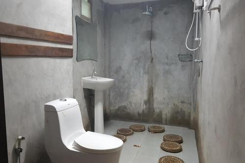 a bathroom with a toilet and a sink and coins at Tontarn Resort and Spa in Khanom