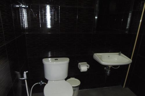 a bathroom with a white toilet and a sink at Tontarn Resort and Spa in Khanom