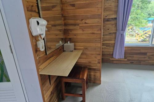 a small room with a wooden wall with a desk at Tontarn Resort and Spa in Khanom