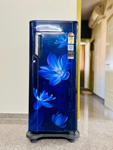 a blue suitcase with blue flowers painted on it at Esha Enclave - Premium Suits in Bengaluru