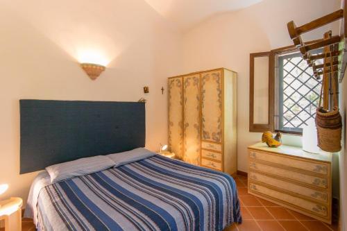 a bedroom with a bed and a dresser and a window at Villa Adamo in Scopello