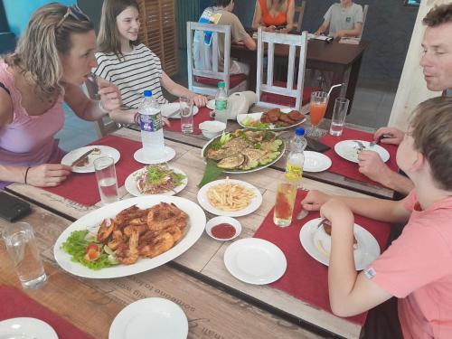 a group of people sitting around a table with food at Morning Star Resorts in Negombo