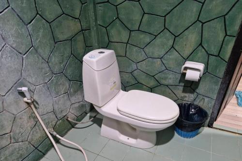 a white toilet in a bathroom with a hose at Tontarn Resort and Spa in Khanom