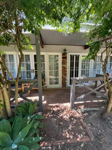 a patio with a picnic table in front of a house at Banksia Cottage in Perth Hills in Perth