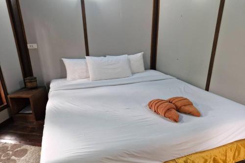 a white bed with two towels on it at Tontarn Resort and Spa in Khanom