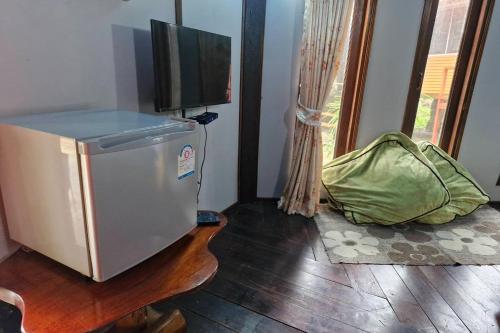 a room with a small refrigerator and a television at Tontarn Resort and Spa in Khanom