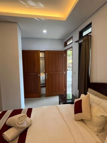 a bedroom with a bed with two towels on it at Mandhasativa Homestay in Singaraja