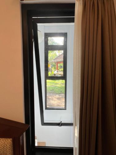 a window in a room with a curtain at Mandhasativa Homestay in Singaraja