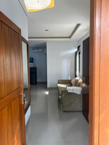a hallway with a couch and a chair in a room at Mandhasativa Homestay in Singaraja