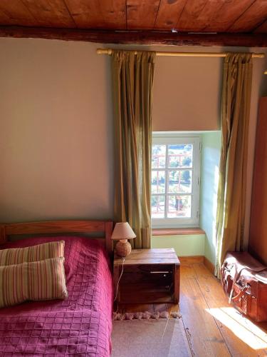 une chambre avec un lit et une fenêtre dans l'établissement Gite vigneron nature, à Montaigut-le-Blanc