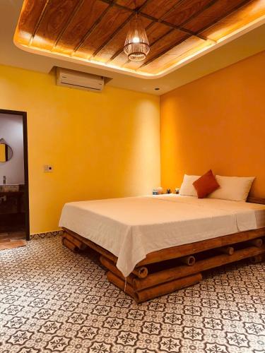 a bedroom with a large bed with yellow walls at Tam Coc Golden Fields in Ninh Binh