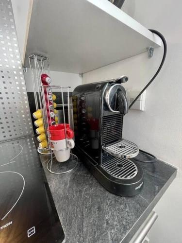 - une cafetière noire sur un comptoir dans la cuisine dans l'établissement Charmant T2 Top Cosy Face à la rade, à Larmor-Plage