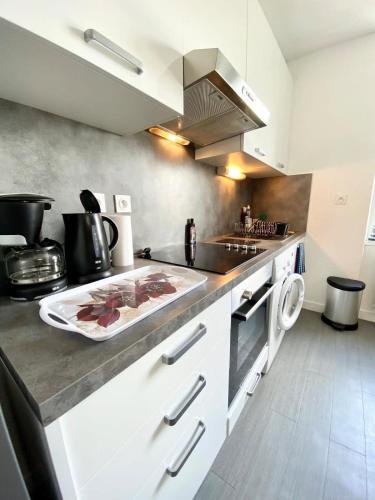 - une cuisine avec un comptoir et une plaque de cuisson dans l'établissement T2 Hyper cosy Plage et port à pieds, à Ploemeur