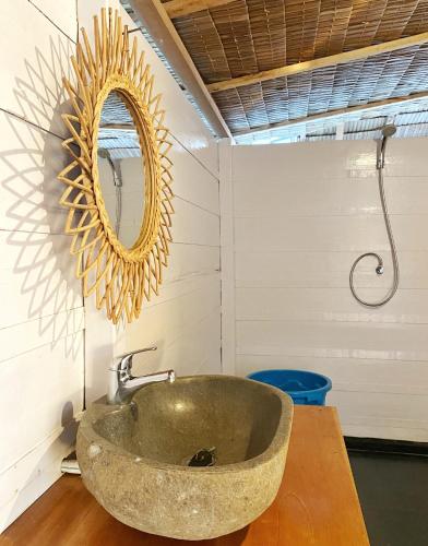 a bathroom with a stone sink and a mirror at Reconnect - Private Island Resort & Dive Center Togean - Buka Buka Island in Ampana