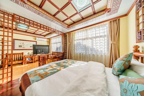 a bedroom with a bed and a tv in a room at Superior Sunshine King Room in Dali Ancient Town