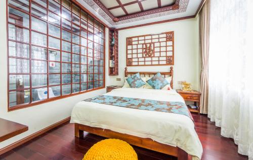 a bedroom with a large bed and large windows at Superior Sunshine King Room in Dali Ancient Town