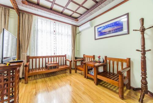 a living room with wooden benches and a table at Superior Sunshine King Room in Dali Ancient Town