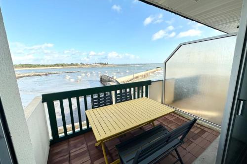 a balcony with a table and a view of the ocean at T3 Duplex Vue mer 180 sur le port de Lomener in Ploemeur