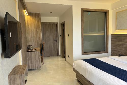 a bedroom with a bed and a large window at Hotel Kushala Grand, Dombivali in Mangrul