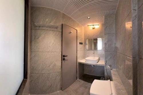 a bathroom with a toilet and a sink at Hotel Kushala Grand, Dombivali in Mangrul