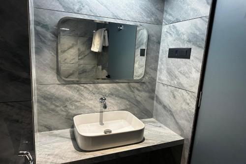 a bathroom with a sink and a mirror at Hotel Kushala Grand, Dombivali in Mangrul