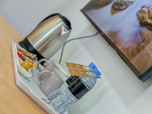a lamp sitting on a table next to a picture at Liwa Guest House 