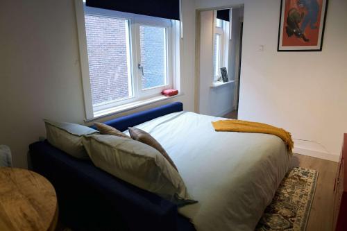 a bedroom with a bed with pillows and a window at City Suite Number 4 in Eindhoven