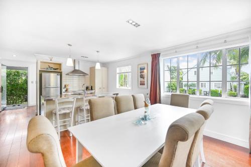 a dining room and kitchen with a white table and chairs at Cooks Cottage 2-4 Bedroom- Russell Cottages Collection in Russell