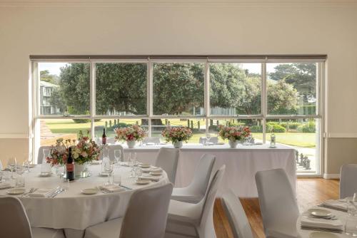 a dining room with tables and chairs and a large window at Mantra Lorne in Lorne
