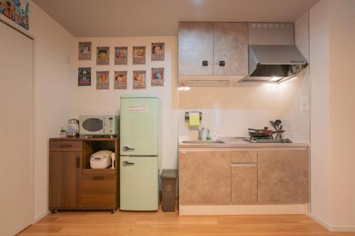 a kitchen with an old refrigerator in a room at フォルモント寺田町204 in Osaka