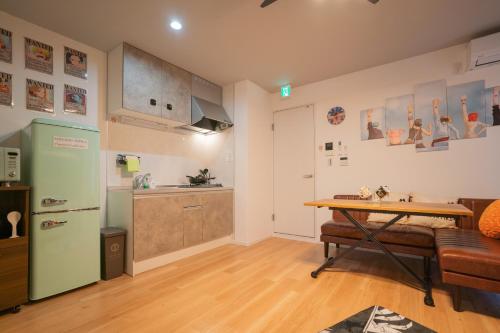 a kitchen with a green refrigerator and a table at フォルモント寺田町204 in Osaka