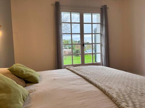 une chambre avec un grand lit avec une fenêtre dans l'établissement l'Echappee belle Seaside break for 8 people, à Plougasnou