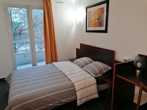 a bedroom with a bed with pillows and a window at Appart Hotel La Defense in Courbevoie