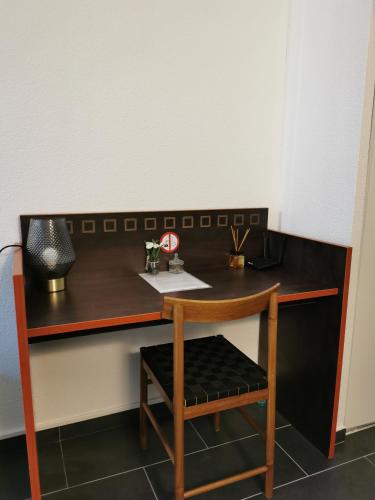 a wooden desk with a chair and a table at Appart Hotel La Defense in Courbevoie
