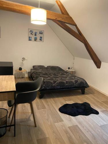 une chambre avec un lit, une table et une chaise dans l'établissement Maison proche circuit le Mans, à Teloché