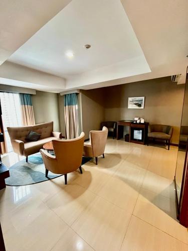 a living room with chairs and a couch and a table at Swiss-Belresidences Rasuna Epicentrum in Jakarta