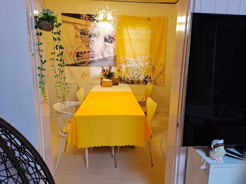 a dining room with a yellow table and a television at 복층형 하우스 in Daejeon