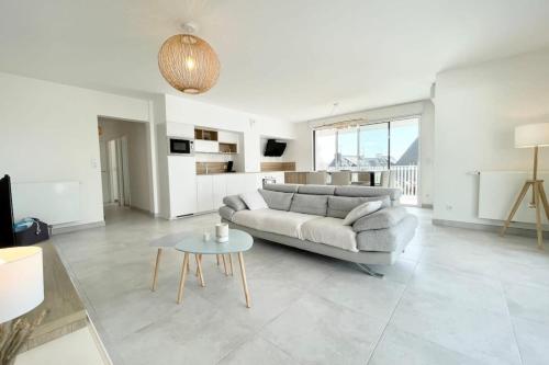 un salon avec un canapé et une table dans l'établissement Spacieux appartement neuf de standing Hyper Cosy, à Larmor-Plage