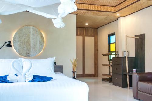 a bedroom with a white bed with a blue bow on it at Long Beach Chalet - SHA Extra Plus in Ko Lanta