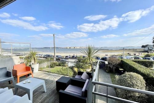 d'un balcon avec des chaises et une vue sur la plage. dans l'établissement Luxury T3 neuf de standing Front de mer vue 180, à Larmor-Plage