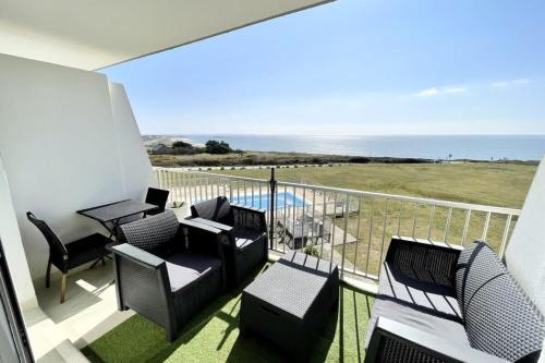 un balcon avec des chaises et une table et l'océan dans l'établissement Magnifique T2 archi cosy Vue mer 180 Piscine, à Guidel