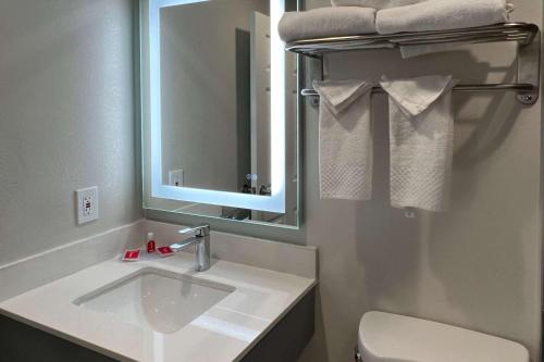a bathroom with a sink and a mirror and a toilet at Quality Inn Tracy I-205 in Tracy