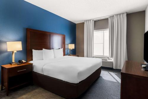 a bedroom with a large white bed and a window at Comfort Inn & Suites near Tinley Park Amphitheater in Tinley Park