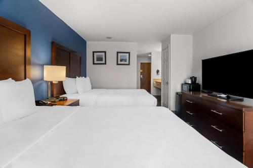 a hotel room with two beds and a flat screen tv at Comfort Inn & Suites near Tinley Park Amphitheater in Tinley Park